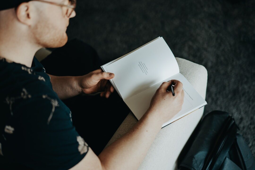 man writing in notebook
